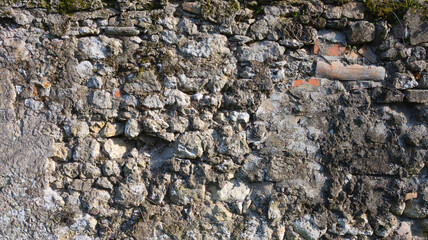 Gray background of an old ruined wall of bricks and grey stones