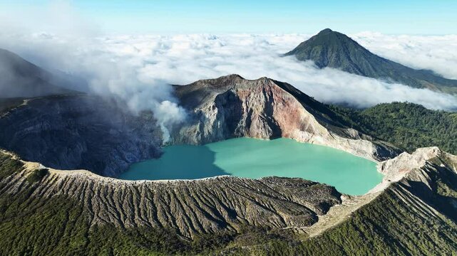 Aerial view Drone shot of fog at Kawah Ijen volcano with turquoise sulfur water lake and sunrise light.Amazing nature landscape view at East Java,Indonesia.Beautiful light Natural landscape background
