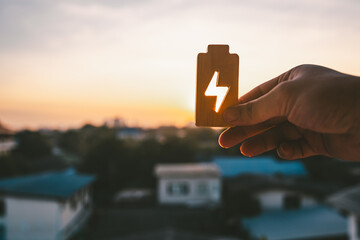 People in a common household holding a symbol of electricity to shine at the sun. The concept of...