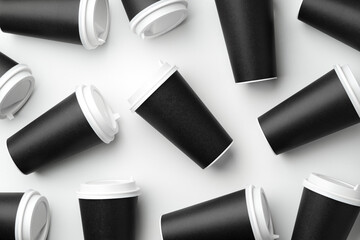 Multiple black takeaway coffee cups arranged in a repeating pattern on a white surface