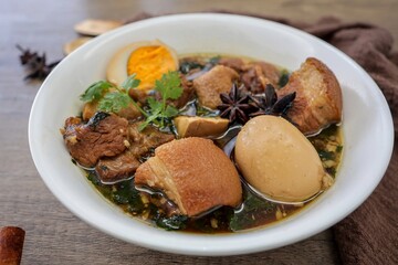 Seasoned eggs, hard boiled eggs and pork belly in Chinese Five Spices Sauce,Five Spice Egg with pork, thai called kai pa lo, boiled eggs and pork in brown soup