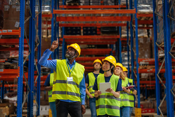 Warehouse workers inspecting inventory on high shelves