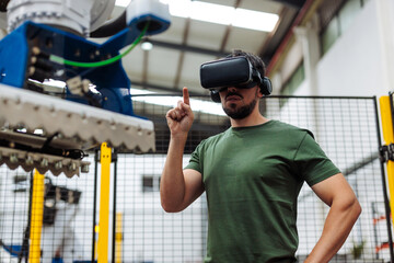 Industrial engineer using virtual reality goggles to control robotic arm in factory