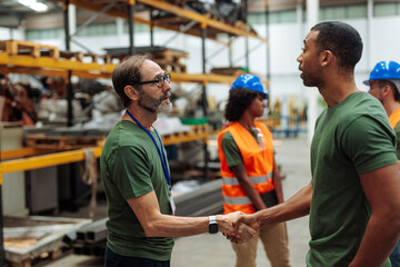 Managers shaking hands in warehouse: teamwork and collaboration in logistics