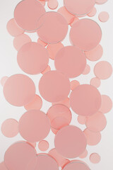 White abstract background with flying pink plastic circles, pattern, top view. 3D illustration with circles texture in cosmetic, gentle, airy, fashion, geometric style for sale, advertising, design.