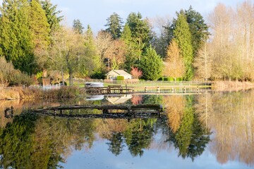 Autumn, reflection of trees and house in the lake. Landscape for background