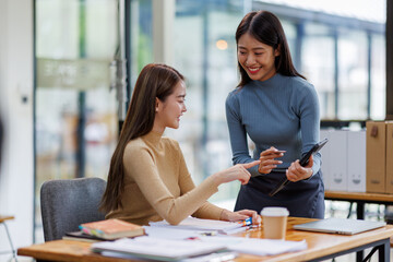Fototapeta premium Two asian female creative agency casual meeting discussion working with laptop, analyze planning and financial statistics and investment market at office. 