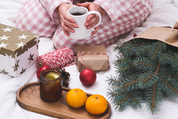 A beautifully cozy winter scene that features wrapped gifts, fresh citrus fruits, and a comforting warm beverage