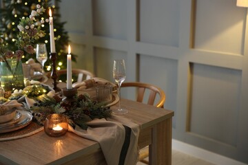 Christmas celebration. Festive table setting with dishware, glasses and decor in room