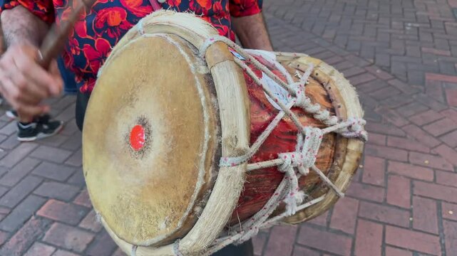 Striking shot of a man playing the tambora on the historic streets of colonial Santo Domingo, blending the energy of traditional Dominican music with the ancient architecture