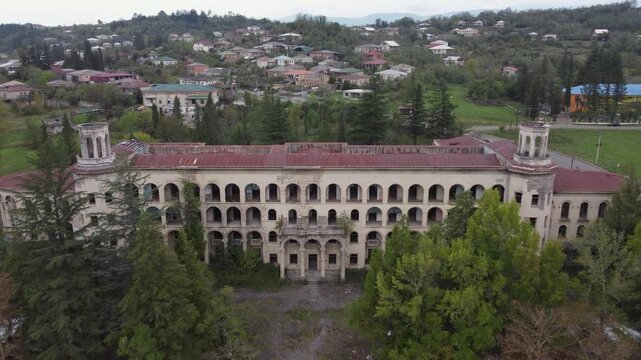 Aerial descends to portico entrance of abandoned sanatorium in Georgia