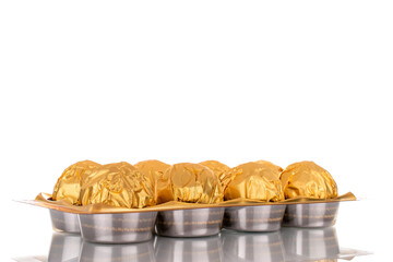 Several chocolate candies wrapped in gift paper, close-up, isolated on a white background.