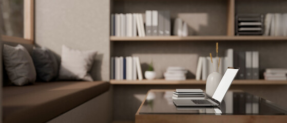 A close-up side view of a laptop on a coffee table in a cozy contemporary beige living room.