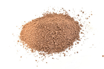 A pile of ground cocoa lies on a white surface.