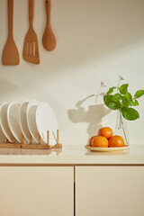 A close-up of a display space for products in a cozy kitchen counter. A disk of orange, wooden...