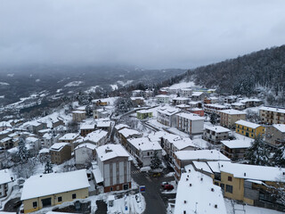 Snow covering the roofs of bore, a small town in the apennines mountains in italy during winter