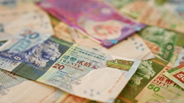 Hong kong dollar banknotes spread randomly capturing the rich details and vibrant colors of different denominations.