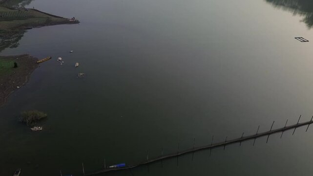 4k footage of a lake with calm water in the morning, covered in a thin mist