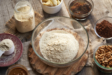 Ingredients for homemade protein chocolate bars - soaked dates, peanuts, raw cacao and whey protein powder