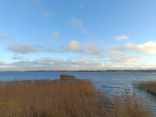 Gudeliai lake during sunny day. Sunny day with white and gray clouds in blue sky. Wavy lake. Horizon over water. Gudeliu ezeras.