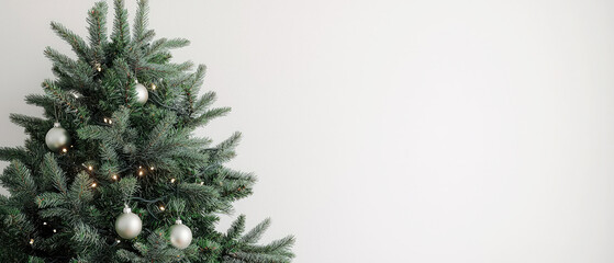 Fototapeta premium Minimal mock up with Christmas tree in empty modern room with soft natural light. Elegant gold ornaments, garland add a touch of holiday warmth for contemporary background.Generative ai