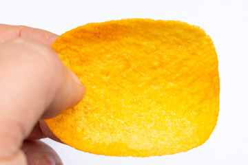 A hand holding a yellow chip