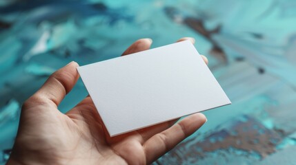 A hand holding a white card with no writing on it
