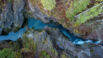 A stream and waterfall in the Walchenklamm gorge in the Bavarian Forest in late autumn. Rocks covered in moss and trees without leaves. mysterious and enigmatic, aerial View