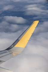 A high-resolution photo of a plane wing and blue sky viewed through an airplane window, symbolizing aviation, travel, vacations, and early booking opportunities