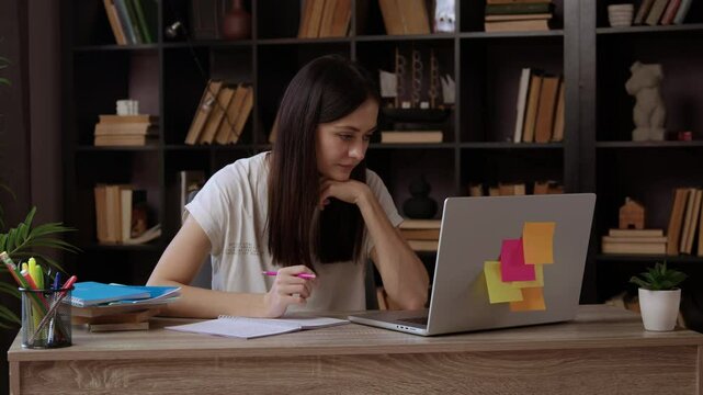 Woman student reviews academic content on laptop in library