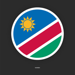 Namibia circle flag icon with shadow on dark background. Namibia button icon with white border isolated dark grey background	