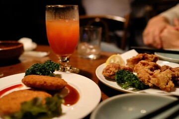 Cream croquettes, karaage (fried) chicken, and a tequila sunrise cocktail at Vagabond, a jazz cafe and “drinking den” with live music in Shinjuku - Tokyo, Japan