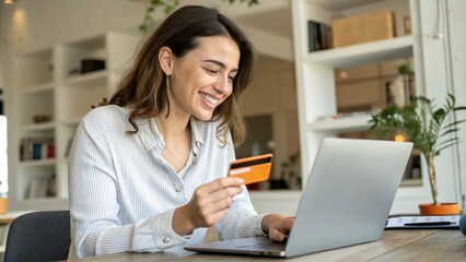 Fototapeta premium Happy office manager shopping online, browsing web stores, buying annual mobile app membership spending her salary holding orange credit card in hand 