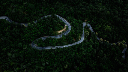 beautiful curve road and green forest in the rain season for backgrounds, rural routes connecting the city in north of thailand.