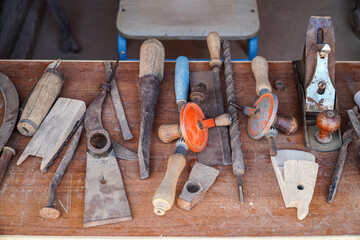 A captivating display of aged carpentry tools, showcasing their rustic charm and historical significance. Each piece tells a story of skilled craftsmanship. Antique Carpentry Tools Collection.