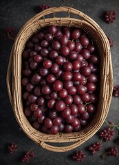 Overhead view of wicker basket overflowing with juicy red grapes, production, abundance, crops, gourmet