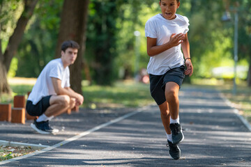 Trainer works with a boy to improve speed and running technique in the park. Focused on building agility and endurance, the outdoor training session promotes healthy physical activity for kids.