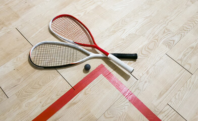 Squash rackets and ball on court floor, top view
