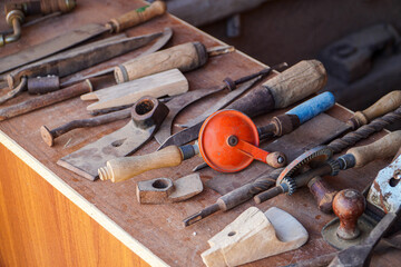 A collection of antique hand tools on a wooden surface, showcasing the craftsmanship of old woodworking and carpentry practices. A Showcase of Old Carpentry and Woodworking Instruments.