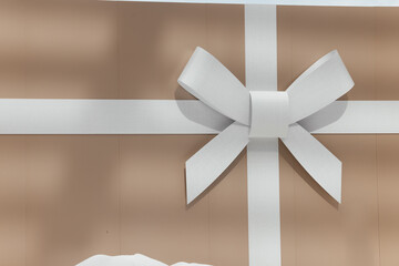 A white bow on a gift box with Christmas presents. A New Year concept.