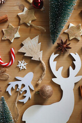 Various Christmas decorations in neutral colors on wooden background. Flat lay.