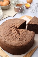 Cut chocolate sponge cake and ingredients on table, closeup