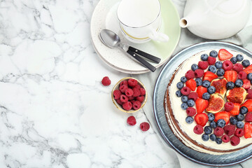 Delicious chocolate sponge cake with berries served on white marble table, flat lay. Space for text