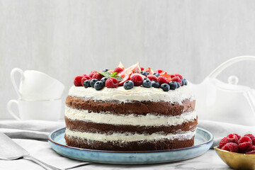 Delicious chocolate sponge cake with berries served on white table