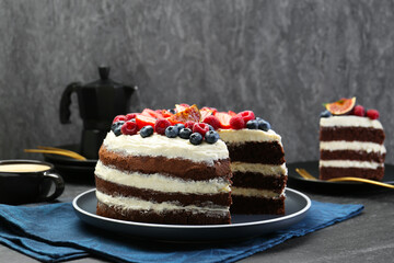 Delicious chocolate sponge cake with berries served on black table