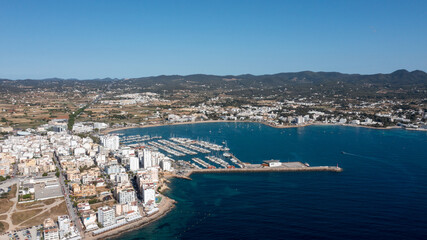 Obraz premium Aerial drone photo of a beach in the town of Sant Antoni de Portmany on the island of Ibiza in the Balearic Islands Spain showing the boating harbour and the beach known as Playa de San Antonio