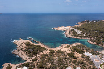 Aerial drone photo of a beach in the town of Sant Antoni de Portmany on the island of Ibiza Balearic Islands Spain showing the ocean front and Cala Alto de Porta beach in the summer time.