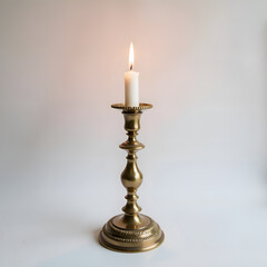 A vintage brass candle holder with a lit candle on a soft background for warm ambience and decorative inspiration, photography of still life concept.