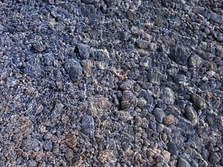 Pebbles and stones in transparent water.