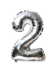 shiny silver foil balloon shaped like number two, reflecting light